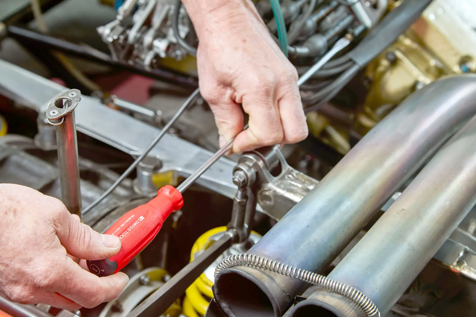 A mechanic working on a machine. Photo by PB Swiss Tools on Unsplash