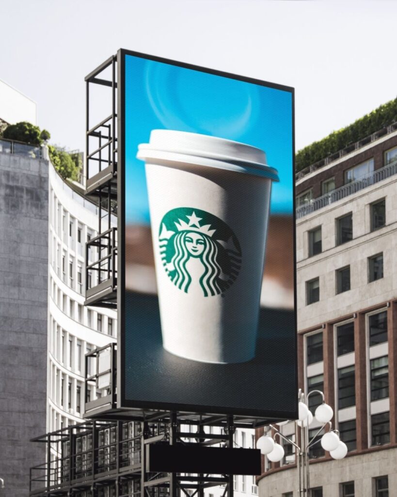 A Starbucks cup on a large vertical billboard