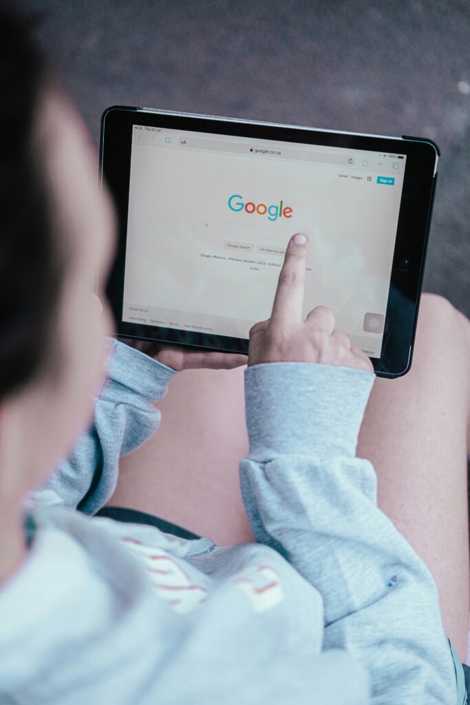 A person holding a tablet displaying the Google home page. Photo by Duncan Meyer on Unsplash