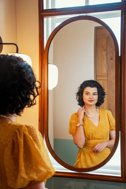 Woman looking at herself in the mirror. Photo by Gabriel Tovar on Unsplash