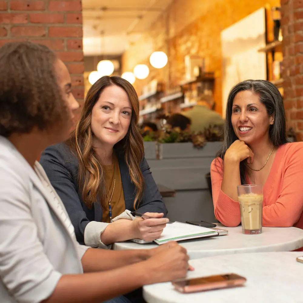 Four women sitting at a table networking. Photo by LinkedIn Sales Solutions on Unsplash.